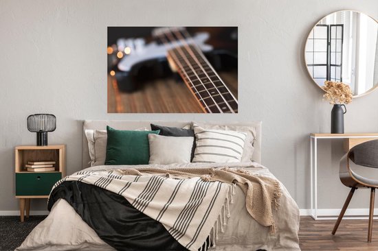 Une guitare basse repose sur une table Poster 120x80 cm - Tirage photo sur Poster (décoration murale salon / chambre)