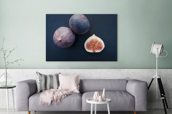 Canvas Schilderij Drie vijgen met opengesneden vrucht op donkerblauwe achtergrond - 120x80 cm - Wanddecoratie