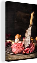 Un couteau de boucher en viande crue sur une assiette toile 120x180 cm - Tirage photo sur toile (Décoration murale salon / chambre) XXL / Groot format!