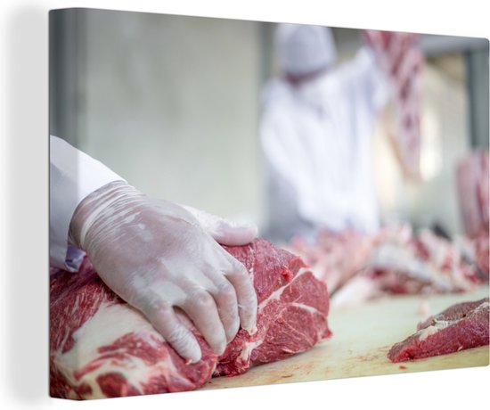 Le boucher découpe la viande en morceaux de toile 60x40 cm - Tirage photo sur toile (Décoration murale salon / chambre)