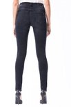 Model in zwarte skinny jeans met hoge taille en vintage wassing.