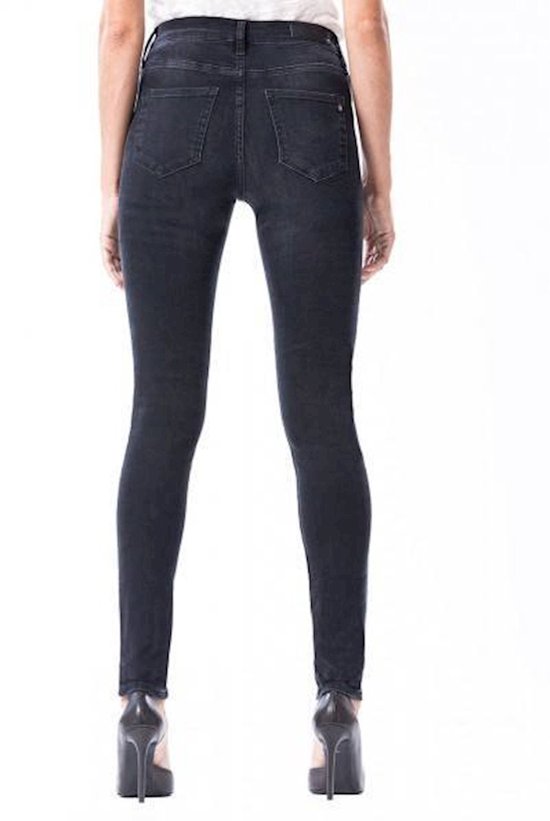 Model in zwarte skinny jeans met hoge taille en vintage wassing.