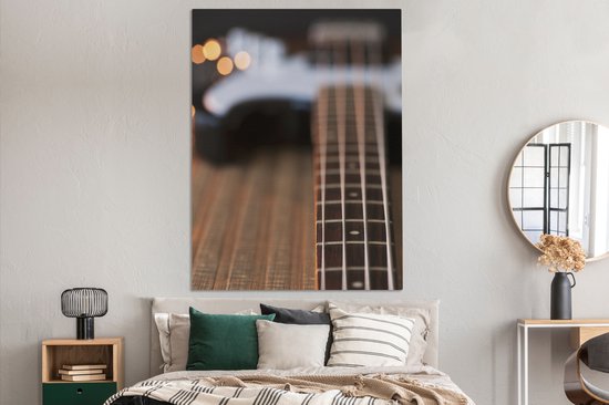 Une guitare basse repose sur le sol Toile 120x160 cm - Tirage photo sur toile (Décoration murale salon / chambre) XXL / Groot format!