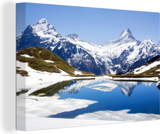 Canvas Schilderij Reflectie van besneeuwde bergen in Zwitserland in een meer - 60x40 cm - Wanddecoratie