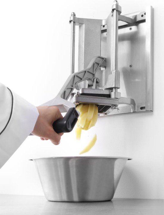 Persoon in witte jas gebruikt fritessnijder, snijdt aardappelschijfjes in een metalen kom.