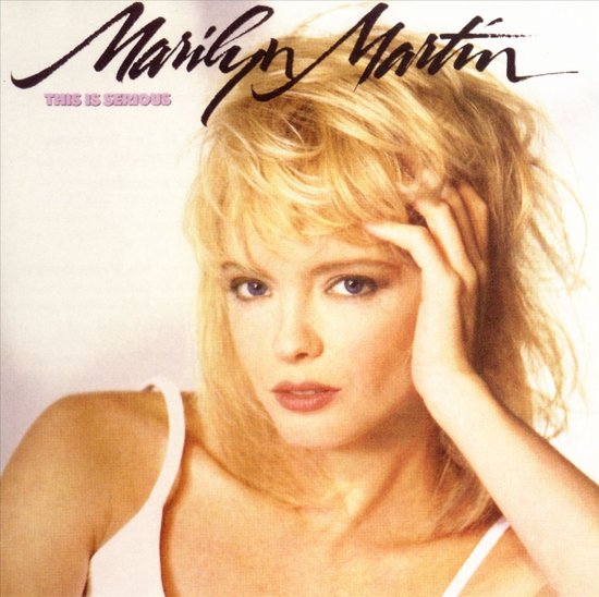 Marilyn Martin, "THIS IS SERIOUS" albumhoes met een blondine met blauwe ogen, lichte huid en blonde coupe. Ze draagt een witte top.
