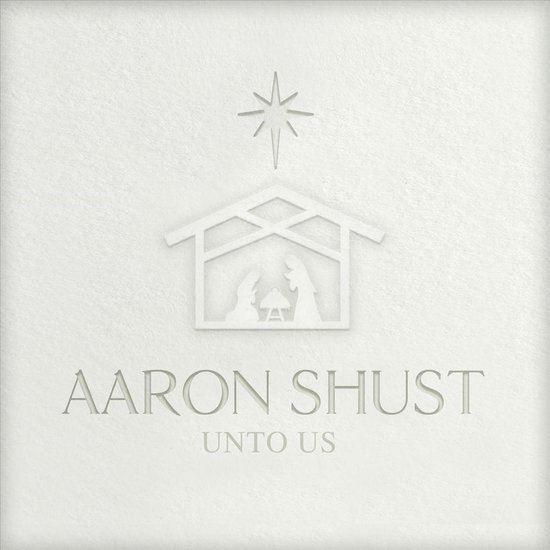 Album cover met een gestileerde kribbe, een ster en tekst 'AARON SHUST UNTO US' in reliëf op een witte achtergrond.