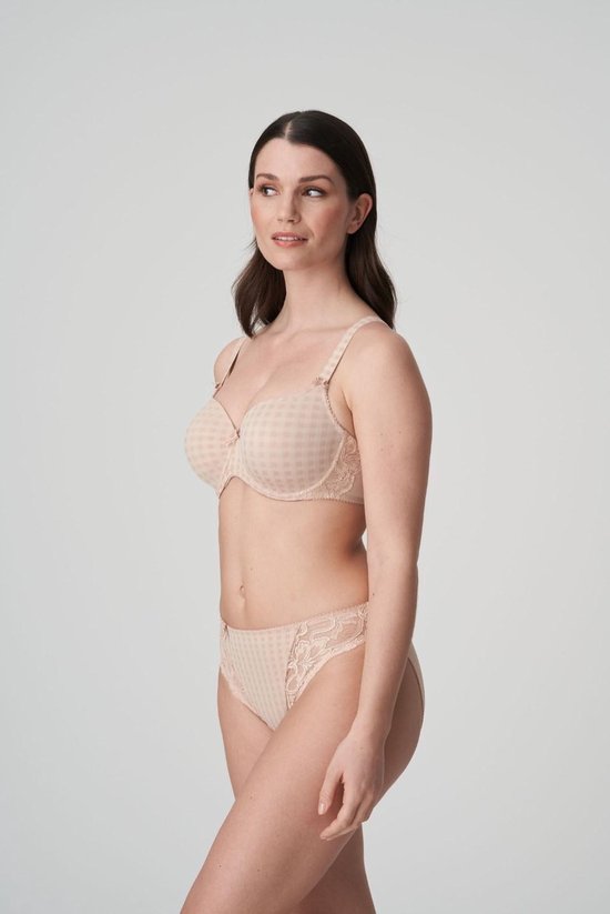Vrouw in beige beha met ruitpatroon en strikjes, en een bijpassende slip. Kanten details op de beha.