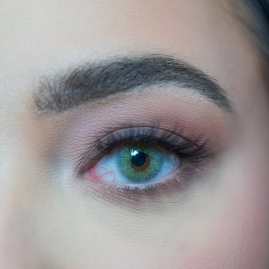Extreem close-up van een oog met een heldere, mintgroene kleurlens.