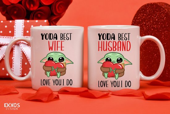 Twee mokken met de tekst "YODA BEST WIFE" en "YODA BEST HUSBAND", beide met Grogu die een hart vasthoudt, op een rode achtergrond met bloemblaadjes.