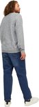 Man met krullend haar, van achteren gezien, draagt een lichtgrijs gemêleerde sweater en een spijkerbroek van blauw denim.