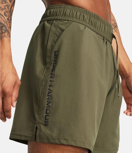 Legergroene sportshort met elastische tailleband, met "UNDER ARMOUR" in zwarte letters op de zijkant.