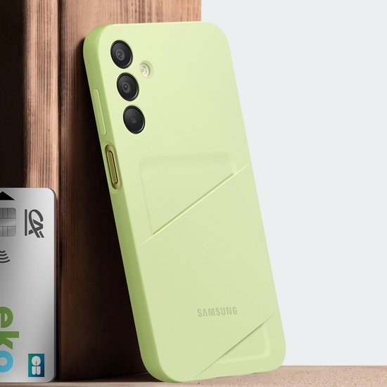 Lichtgroen Samsung telefoonhoesje met sleuf voor pasjes, leunend tegen een houten object.