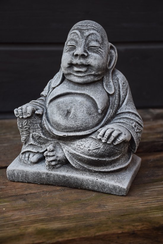 Grijze stenen gargoyle met gedetailleerd gewaad, bloemen en sterrenmotieven, op houten ondergrond.