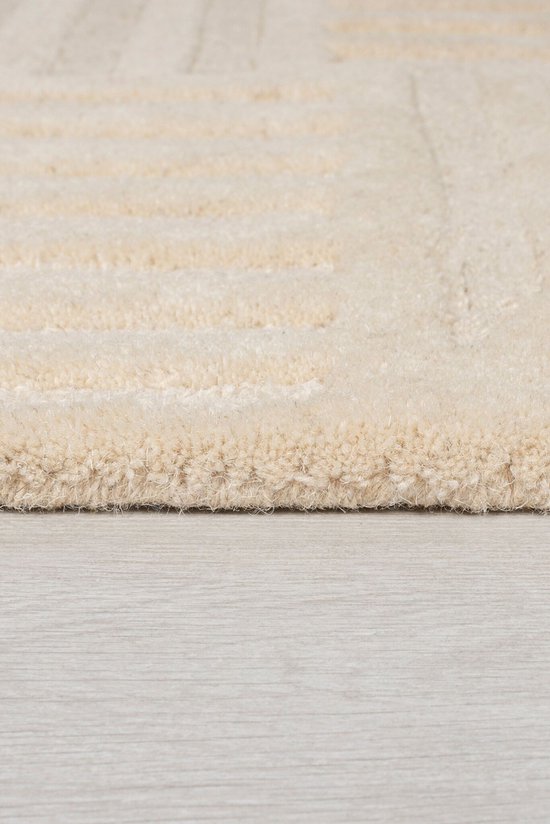 Close-up van de textuur van een beige laagpolig vloerkleed met voelbare lijnen.