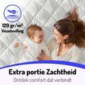 Vrouw en baby op een gewatteerde witte matrasbeschermer. 120 gr/m² vezelvulling voor extra zachtheid.