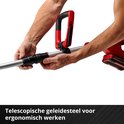 Handen die de telescopische steel van een rode accugrasmaaier verstellen voor ergonomisch werken.