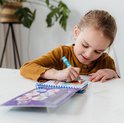 Fille en pull marron dessinant avec un stylo bleu dans un livre de coloriage à l'eau avec des animaux marins.
