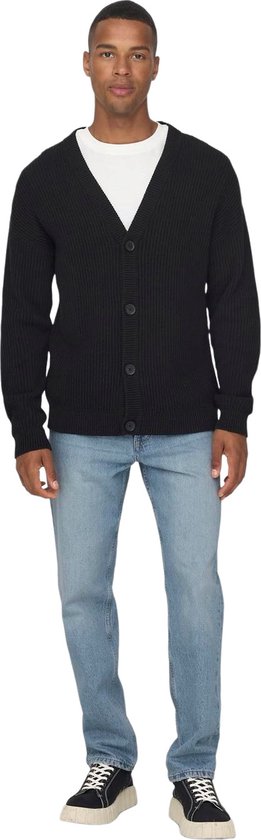 Man in een gebreide zwarte cardigan en lichtblauwe jeans.