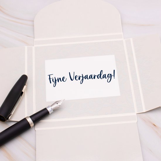 Une carte ouverte avec le texte 'Joyeux Anniversaire !' et un stylo.
