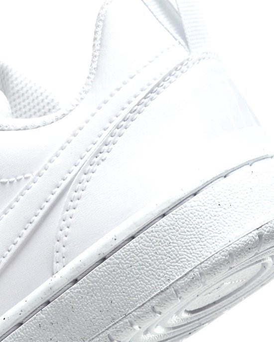 Close-up van de achterkant van een witte Nike sneaker. Logo op de hiel en gespikkelde zool.