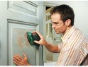 Man met veiligheidsbril schuurt een groene deur met een Bosch multischuurmachine.