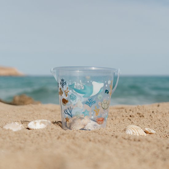 Lichtblauwe emmer met zeelevenprint op het strand.