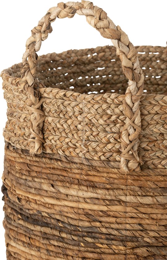 Close-up van een grote jute mand met gevlochten handvatten en een grof geweven onderkant.