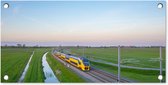 Tuinposter Een trein rijdt door een landschap - 60x30 cm - Tuindoek - Buitenposter