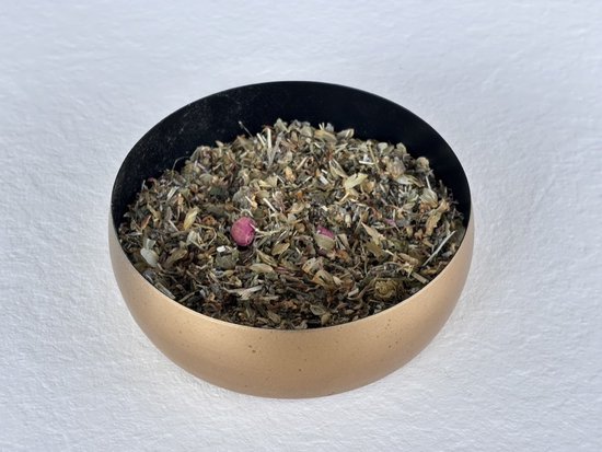 Gedroogde kruidenmix met roze bloempjes in een gouden kom.