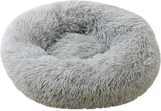 Een ronde, fluffy, lichtgrijze hondenmand op een witte achtergrond.