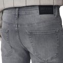 Close-up van de achterkant van een grijze jeans met label 'ONLY & SONS'.