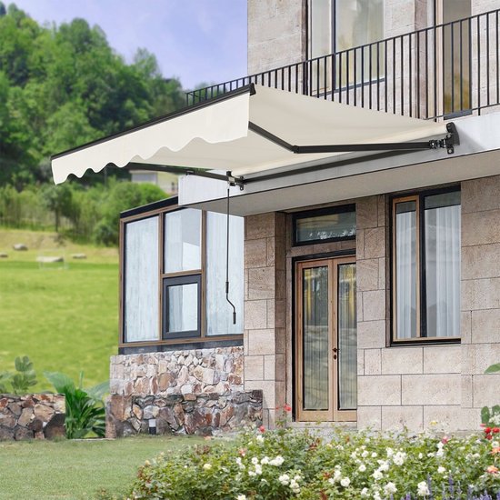 Beige luifel gemonteerd aan stenen huis met buitenmeubilair.