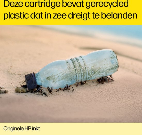 Verlaten plastic fles met zeewier op een zanderig strand.