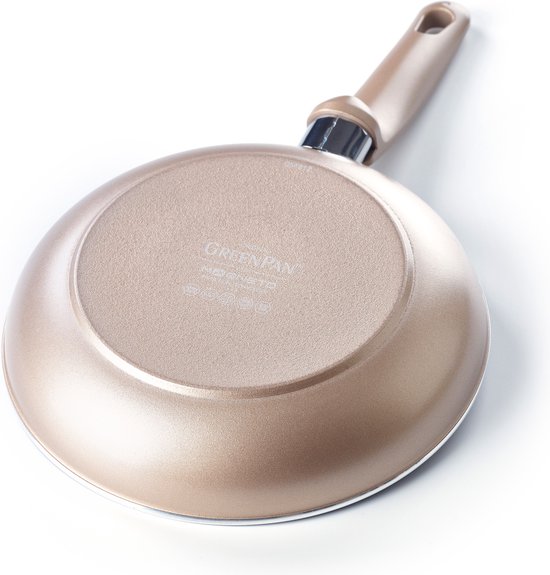 De onderkant van een koekenpan met bronzen buitenkant en een bronzen handvat.