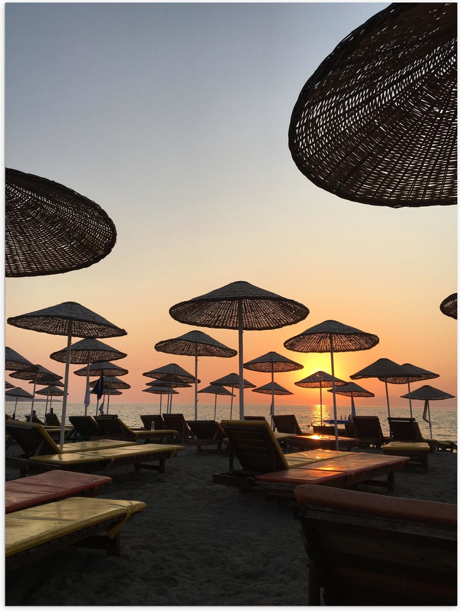 Poster Glanzend – Ligbedden met Rieten Parasols aan het Strand in de Avondzon - 60x80 cm F