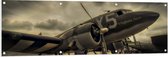 WallClassics - Tuinposter – Vliegtuig met Grauwe Wolken - 150x50 cm Foto op Tuinposter  (wanddecoratie voor buiten en binnen)