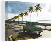 Canvas Schilderij Een groene Cubaanse oldtimer onder palmbomen - 120x80 cm - Wanddecoratie