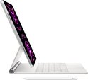 Zilverkleurige iPad Pro met Magic Keyboard en Apple Pencil, display toont abstracte afbeeldingen.