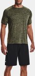 Man in groen gemêleerd sportshirt met korte mouwen en zwarte sportbroek met logo.
