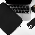 Zwarte laptophoes naast een laptop, telefoon en mok