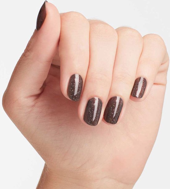 Hand met nagels gelakt met donkerbruine glitter nagellak.