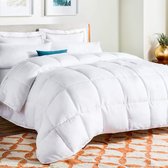 Wit microvezel dekbed met ruitstiksels op een opgemaakt bed met oranje vloerkleed.