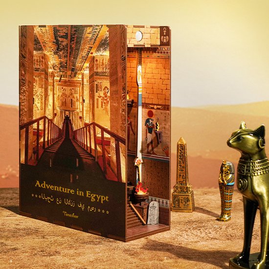 Boekensteun 'Adventure in Egypt' open in een woestijnlandschap met een gouden kat, obelisk en sarcofaag.