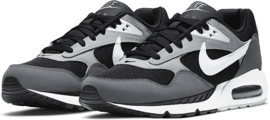 Zwarte Nike sneakers met grijze en witte accenten. De schoenen hebben een witte Nike 'swoosh' op de zijkant en 'Air' op de zool.