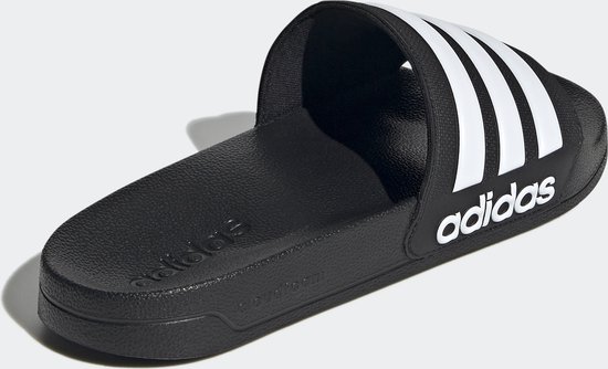 Tongs Adidas noires avec bandes et logo blancs.