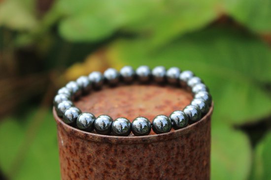 Grijze hematit edelsteen armband van 8mm kralen op een roestige paal.