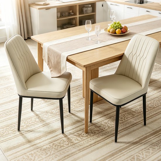 Twee gebroken witte eetkamerstoelen met gestikte rugleuningen en zwarte poten staan naast een houten eettafel op een gestreept tapijt.