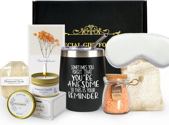 Boîte cadeau avec une tasse noire inscrite, masque pour les yeux, bougie parfumée, savon, sels de bain et carte de fleurs.
