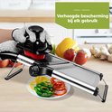 Hand met snijhandschoen gebruikt mandoline om tomaat te snijden. Plateau met gesneden paprika's.
